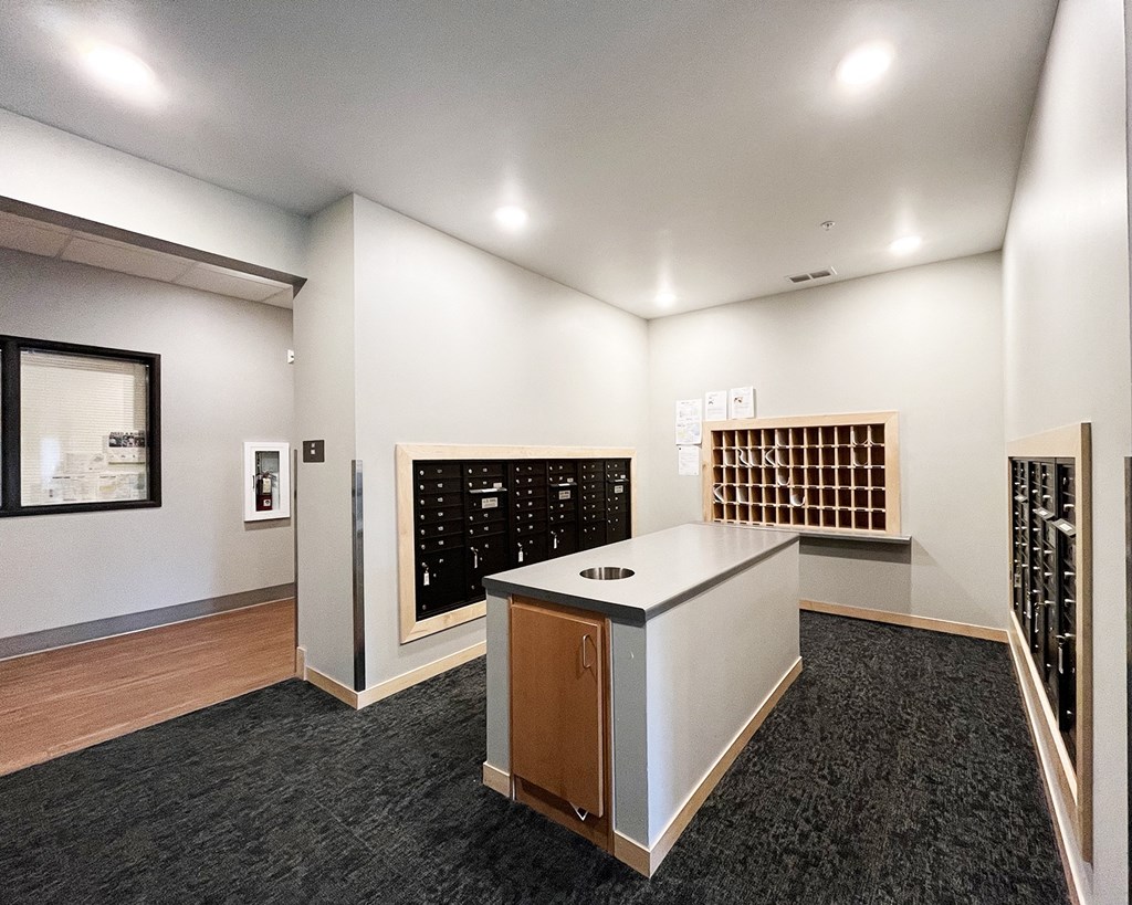 A reception area with a white counter and a black wall with a window.