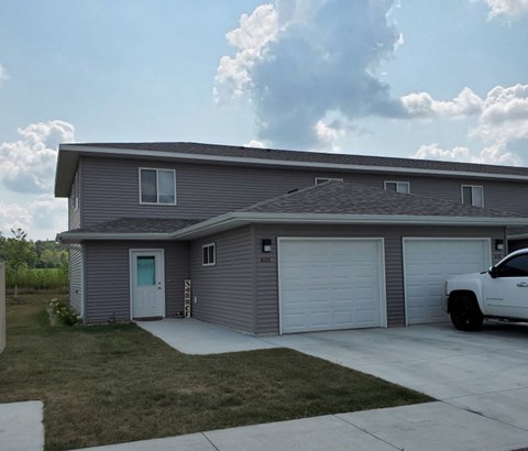 A grey house with a white truck parked in front.