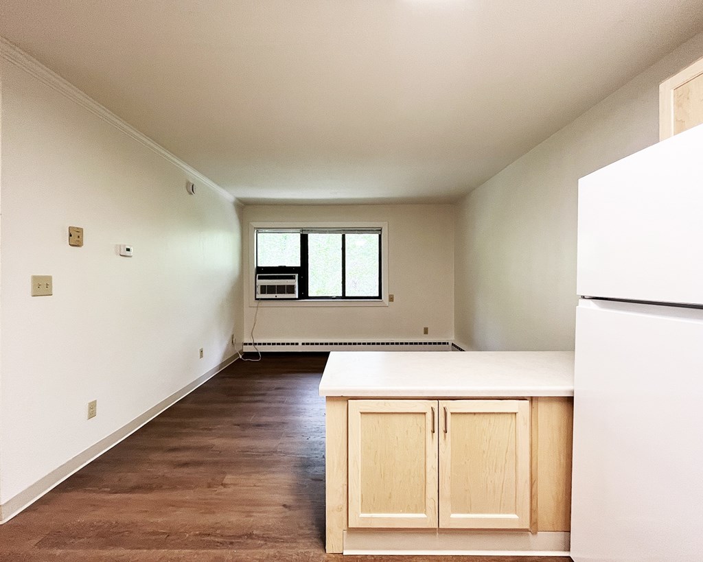 A kitchen with white cabinets and a white refrigerator.