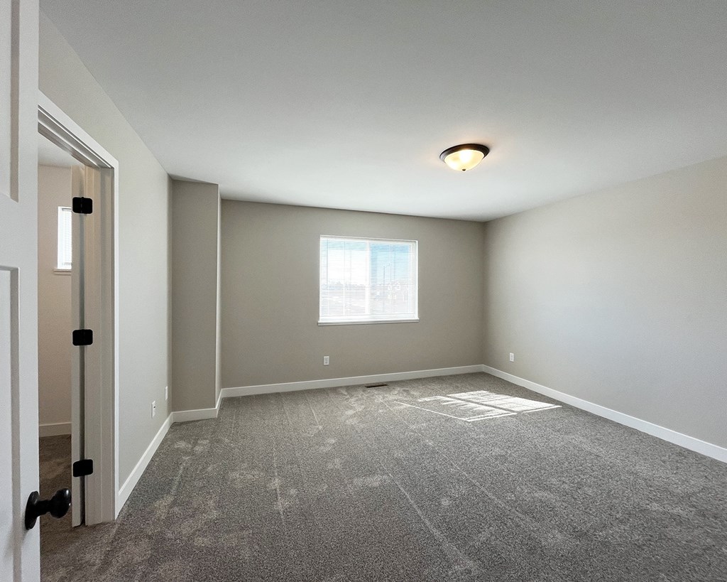 an empty room with carpet and a window