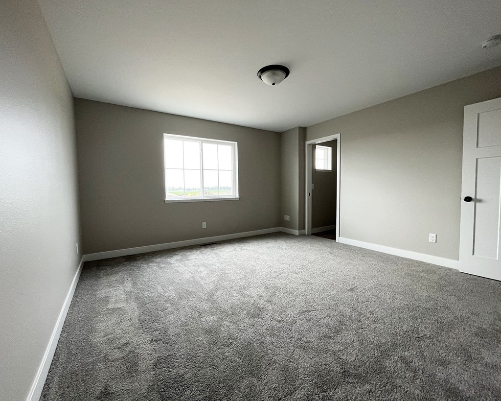 an empty room with a window and door