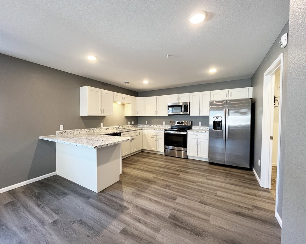 A kitchen with a marble countertop and stainless steel appliances.
