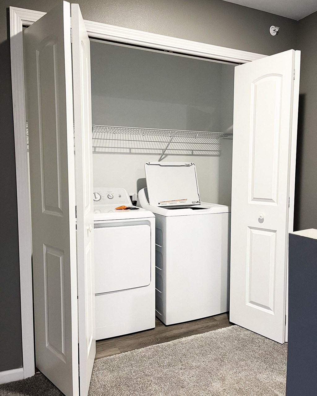 A white dryer and washer are in a small laundry room.
