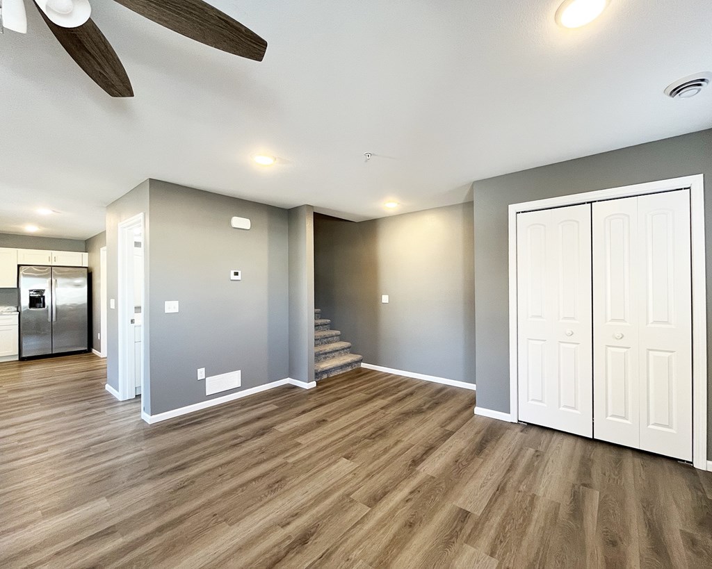 A room with wooden flooring and a ceiling fan.