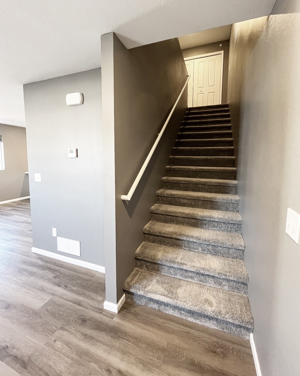 A staircase with a carpeted runner and wooden steps.