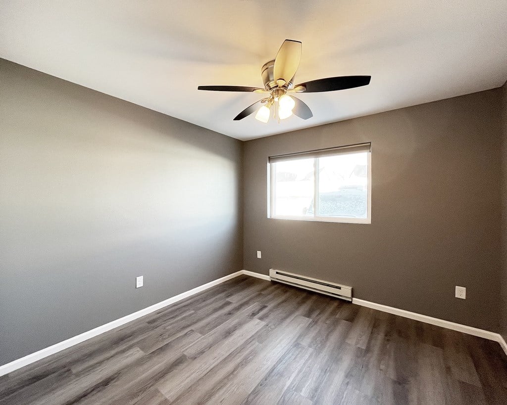 A room with a ceiling fan and a window.