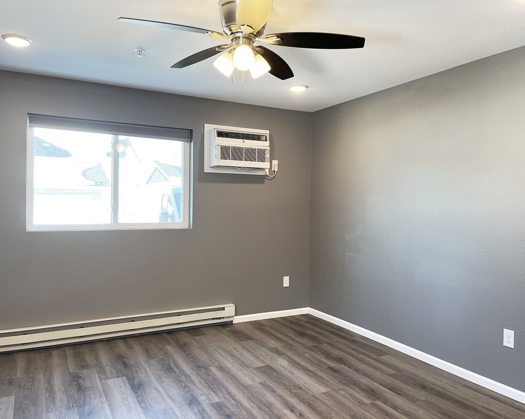 A room with a ceiling fan and a window.