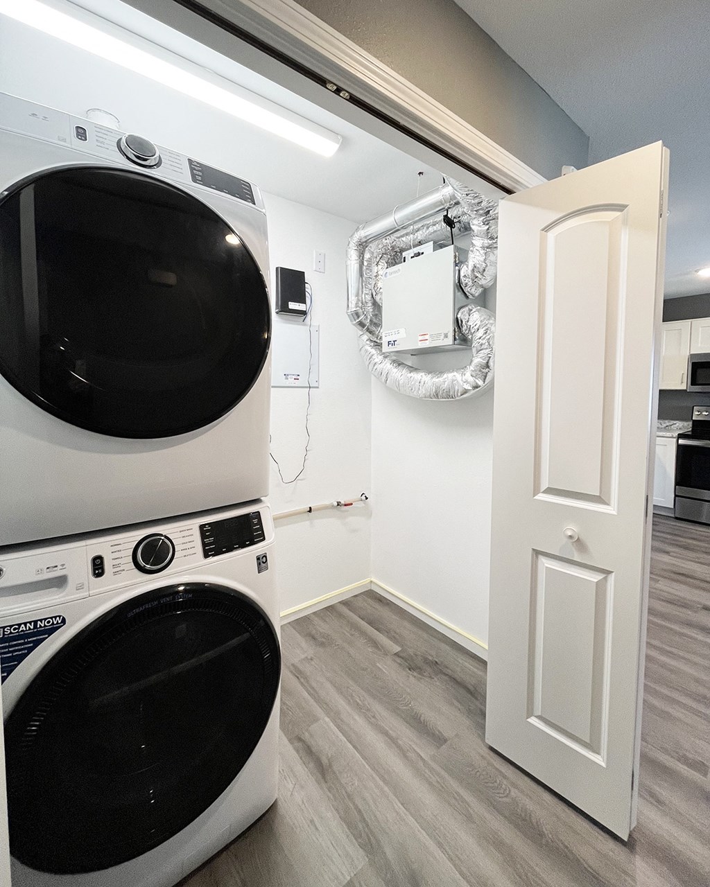 A white door is open to a laundry room with a washer and dryer.