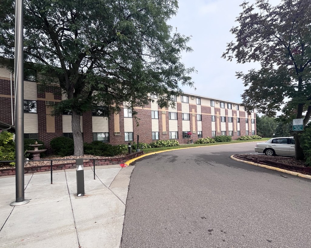 A street view of a residential area with a car parked on the side.