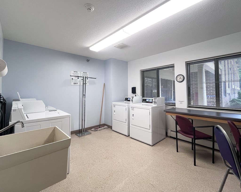 A room with a printer, a cabinet, and a desk.