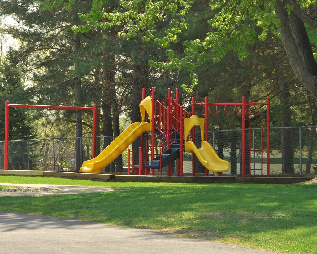 a playground with three slides in a park