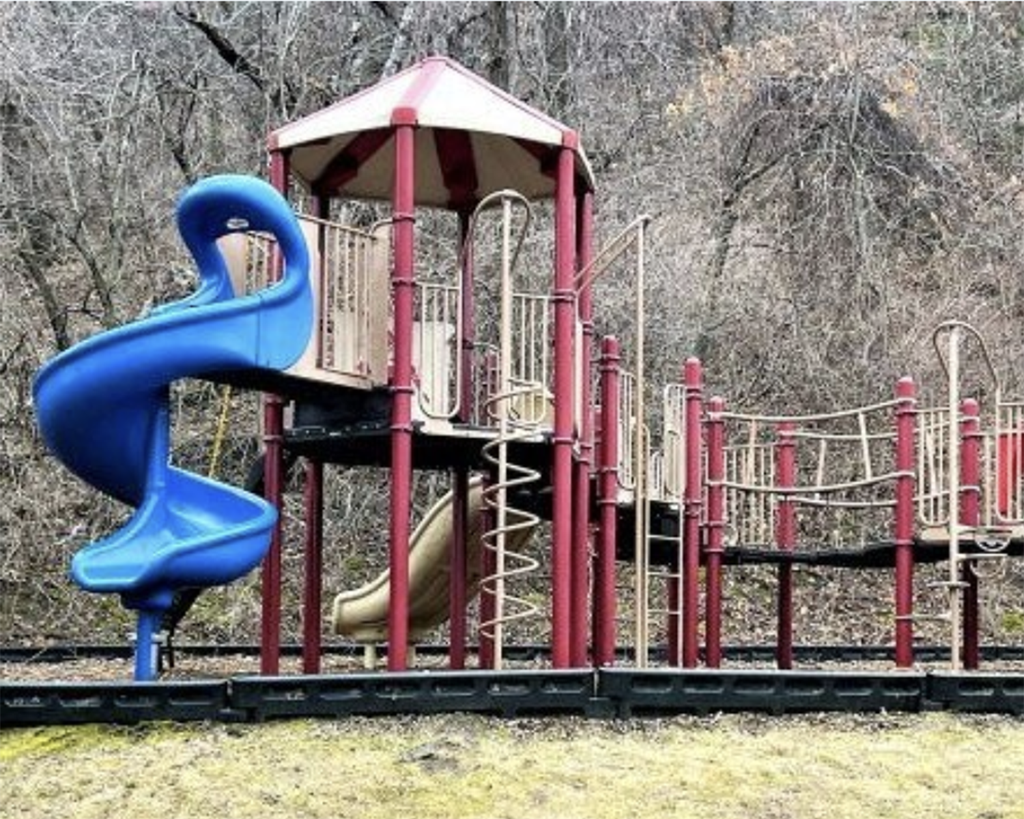 A playground with a blue slide and a red and white structure.