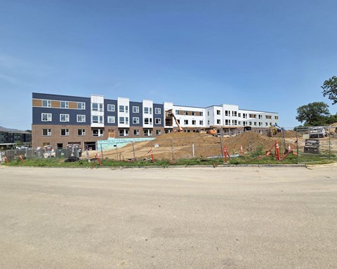 A row of multi-story buildings under construction with a clear blue sky.