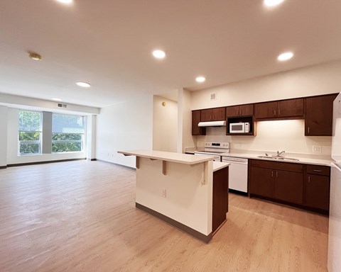 A kitchen with a white island and brown cabinets.