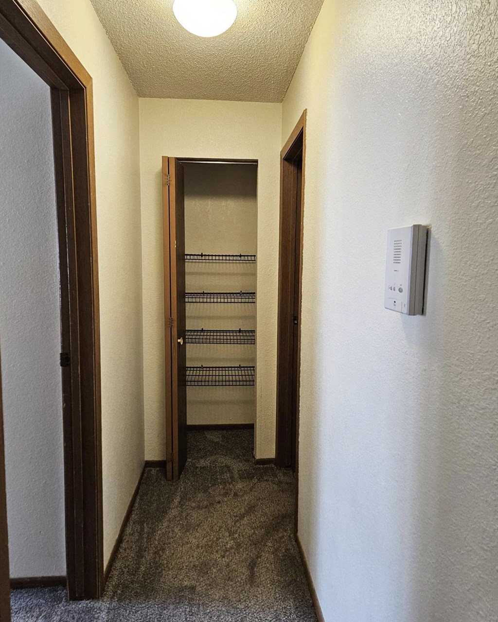 A white wall with a thermostat on it.