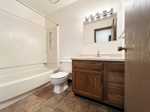 A bathroom with a toilet, sink, and bathtub.
