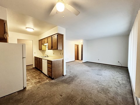 A kitchen with a refrigerator, sink, and cabinets.