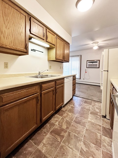 A kitchen with wooden cabinets and a white fridge.