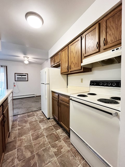 A kitchen with a white stove top oven and white refrigerator.