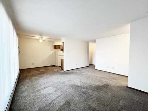 A large empty room with a carpeted floor and white walls.