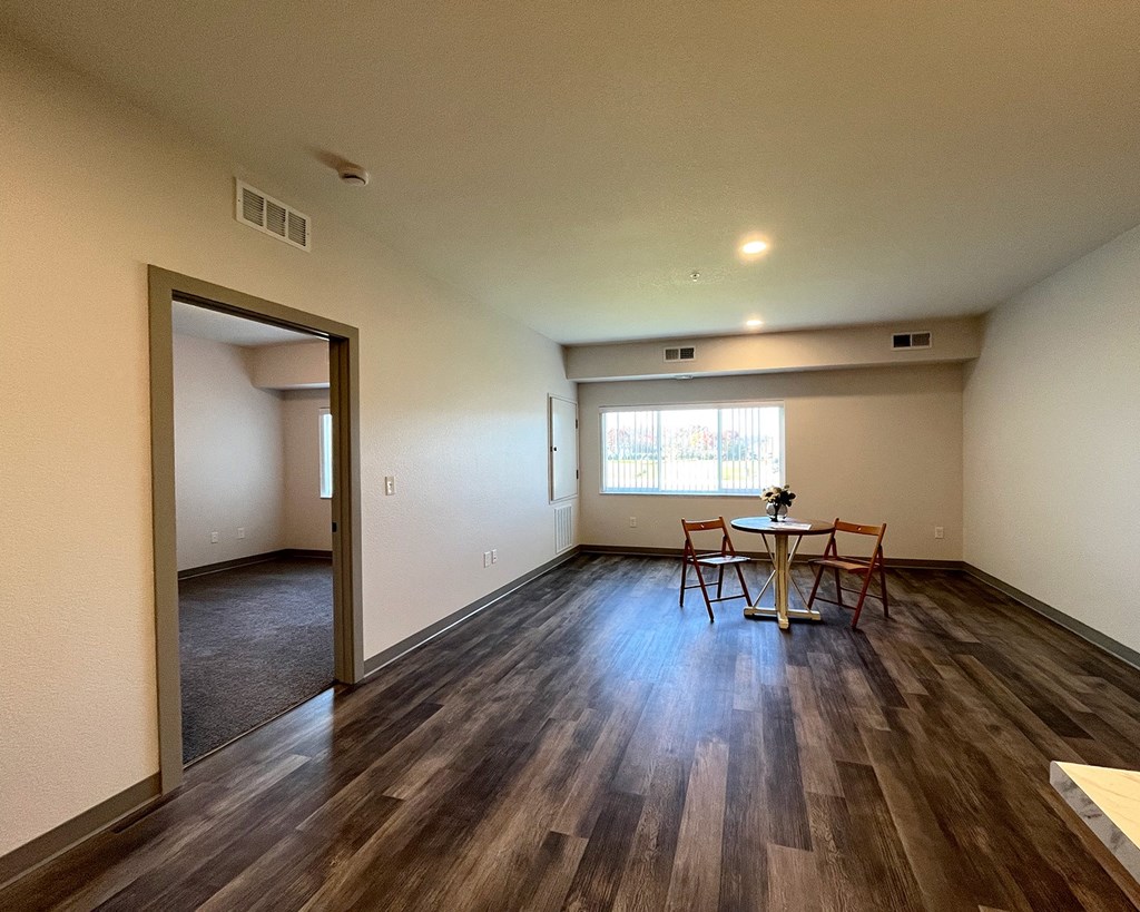 an empty living room and dining room with a table and chairs