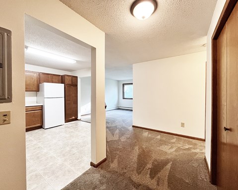 A kitchen with white appliances and brown cabinets.