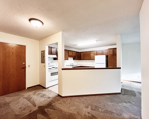 A kitchen with white appliances and wooden cabinets.