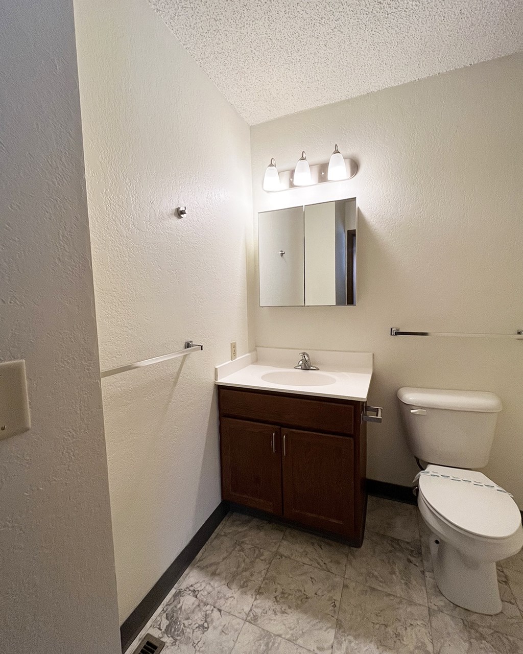 A white toilet sits next to a sink in a small bathroom.