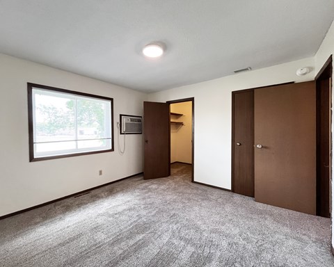 A room with a carpeted floor and a window.