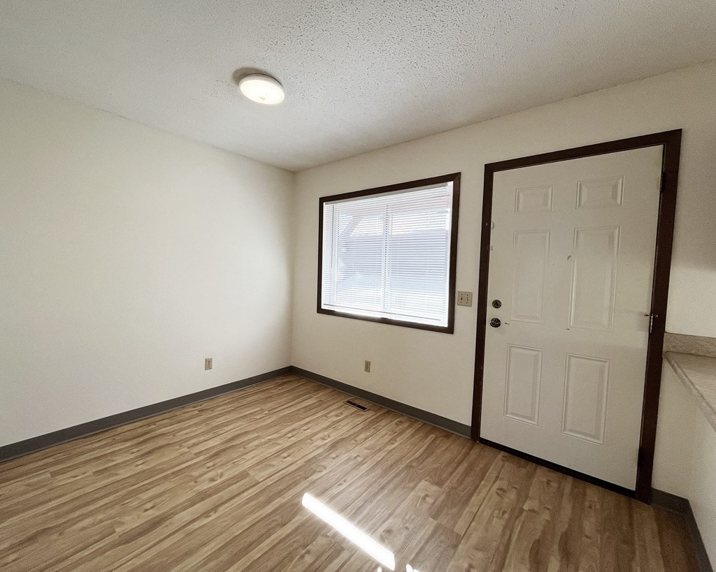 A room with a white door and a window with blinds.