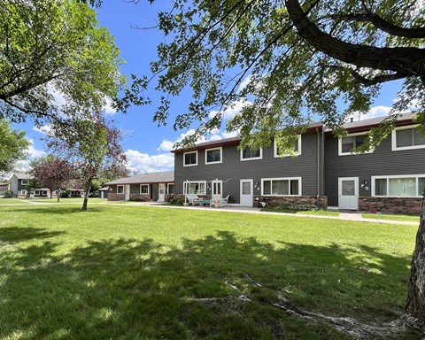 A row of houses with green lawns in front.