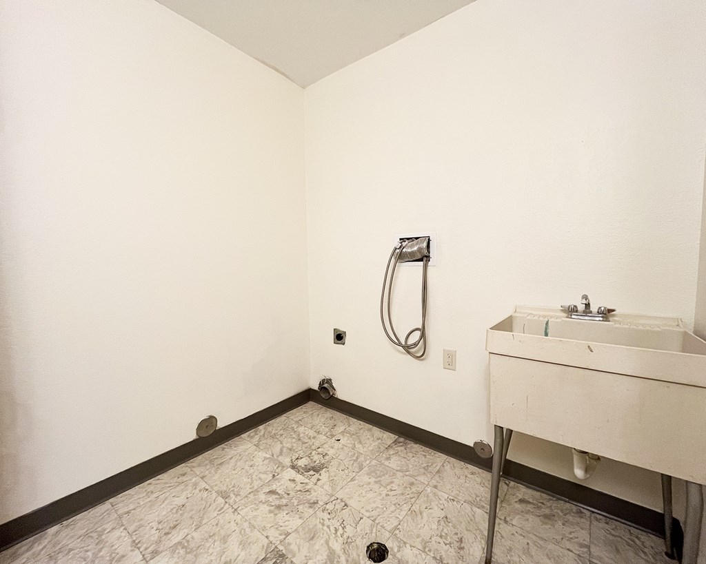 A bathroom with a sink and a shower head.