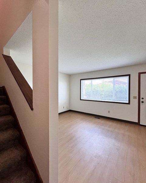 A room with a window and a staircase.