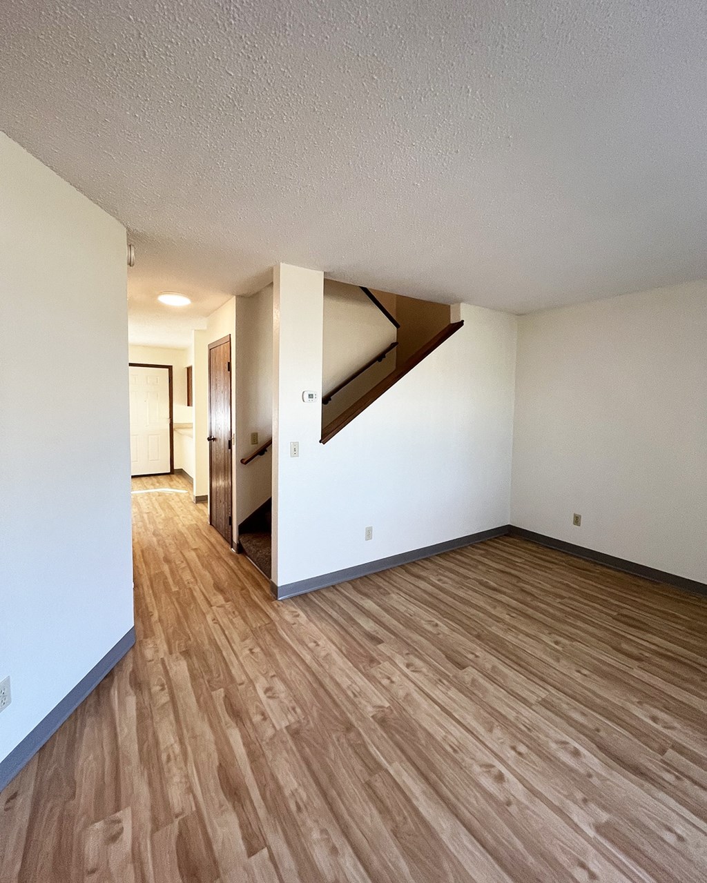 A room with wooden floors and a staircase.
