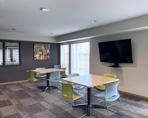 A conference room with a large table and chairs.