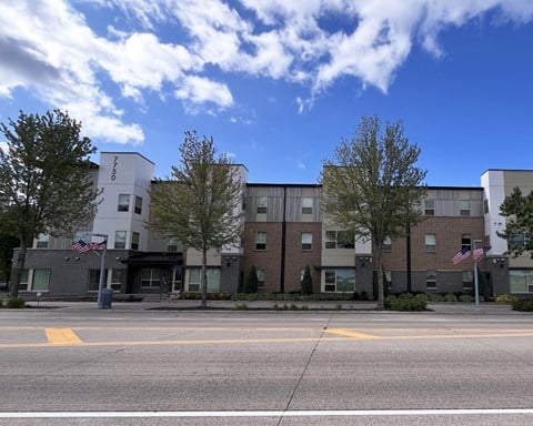 A building with a grey and white facade and a flag on the left side.
