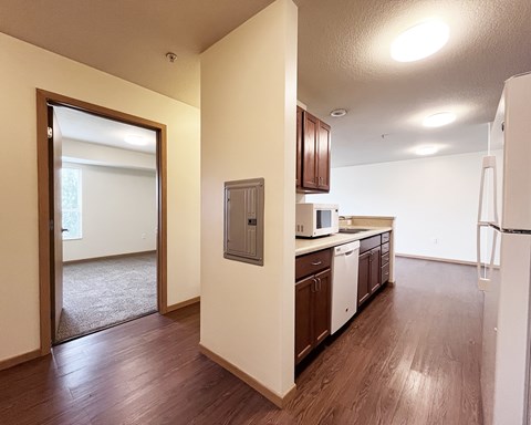 A kitchen with wooden floors and white appliances.