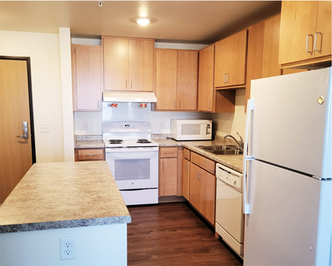 A kitchen with wooden cabinets and white appliances.