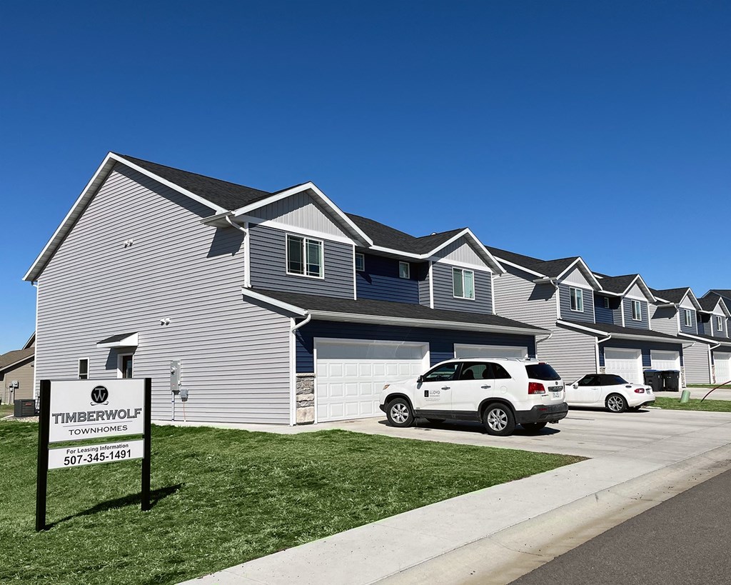 a gray house with a white car parked in front of it