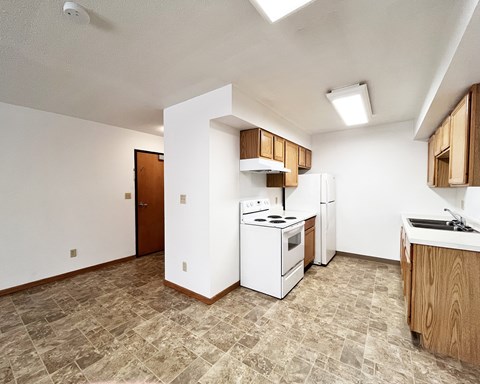 A kitchen with a white stove and wooden cabinets.