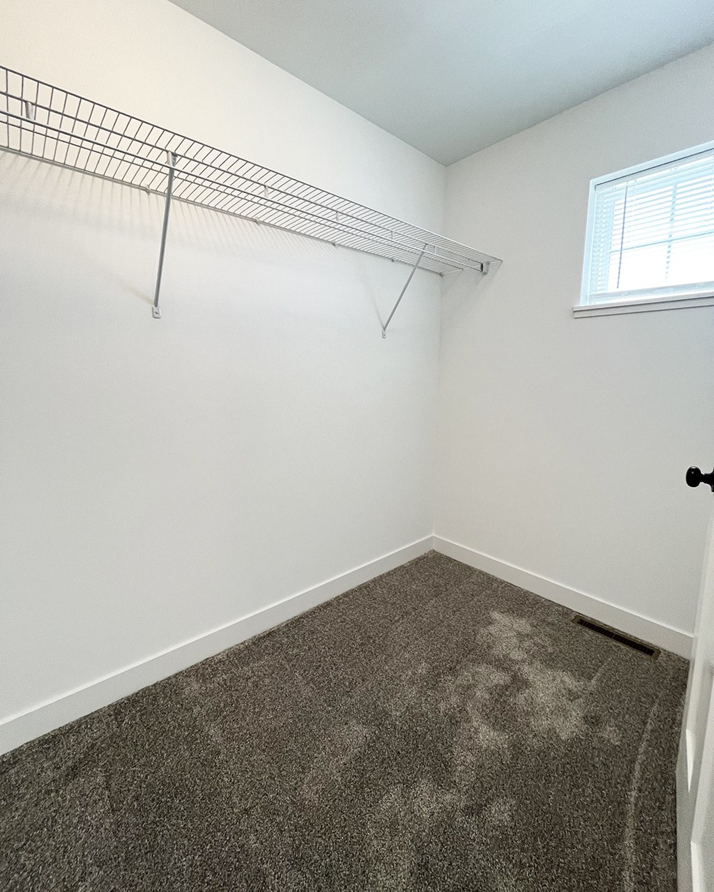 an empty room with a closet and a window