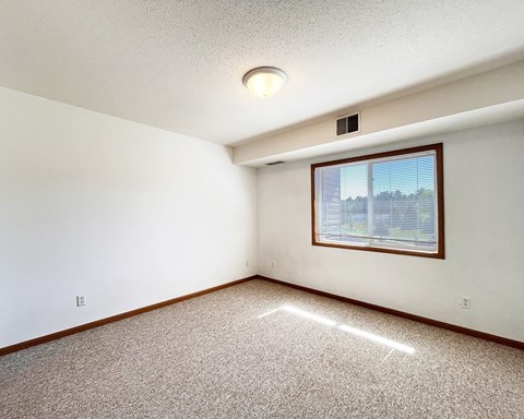A room with a window and a ceiling light.