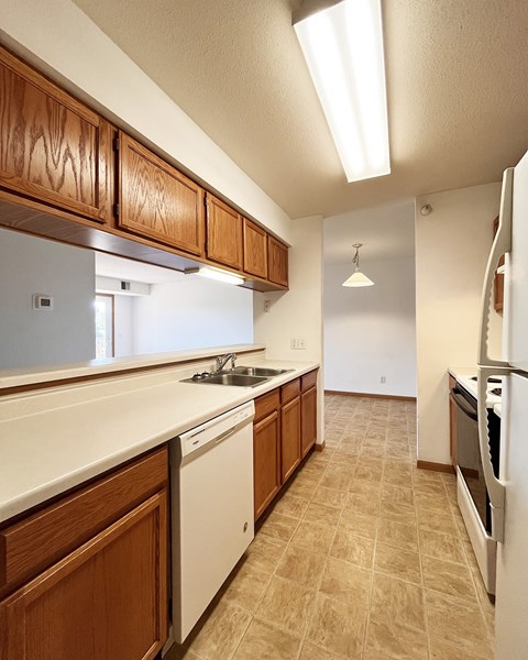A kitchen with wooden cabinets and white appliances.
