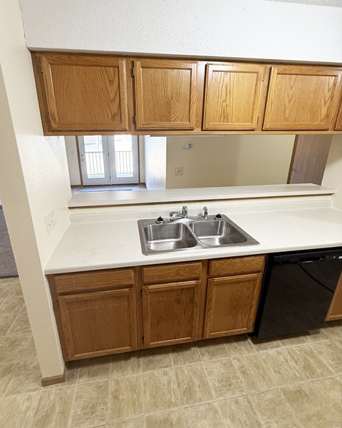 A kitchen with a sink and wooden cabinets.