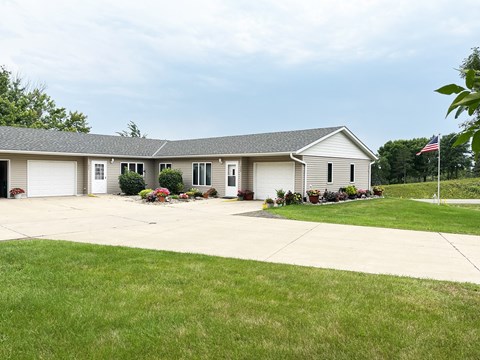 A house with a garage and a flag on the lawn.