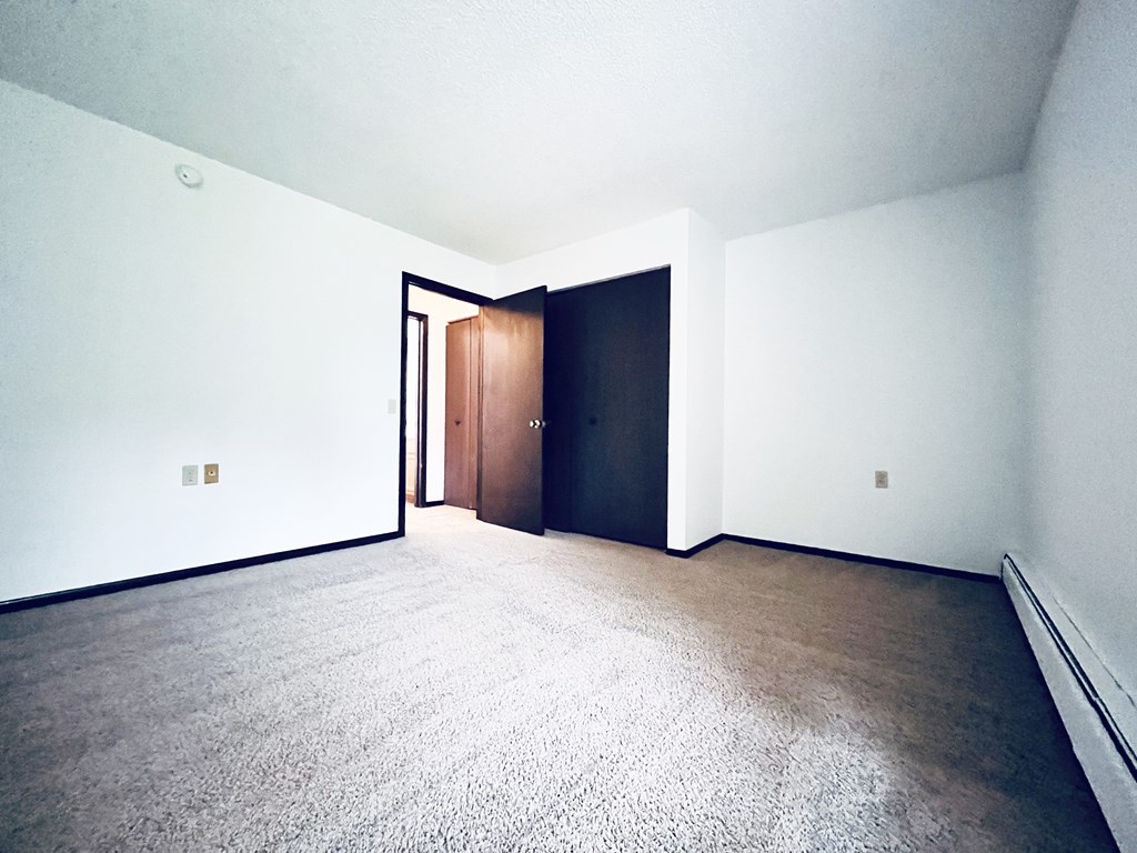 A room with a carpeted floor and a door.