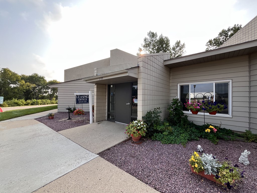 A house with a grey exterior and a gravel driveway.