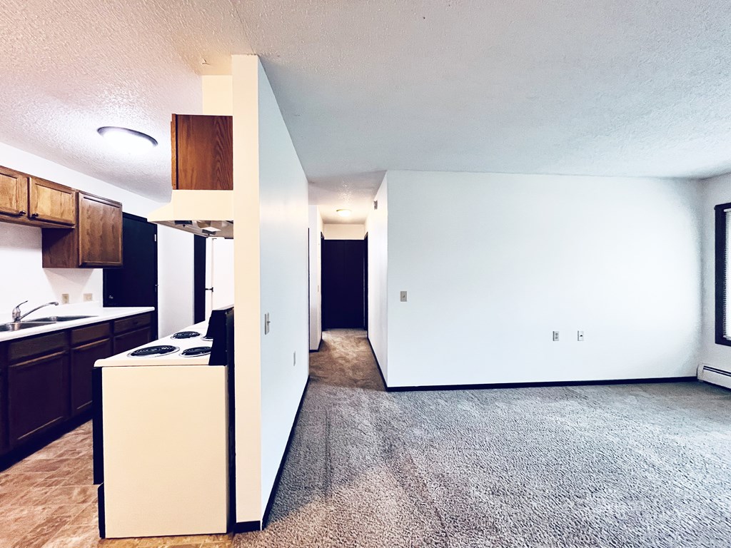 A kitchen with a white fridge and a white wall.