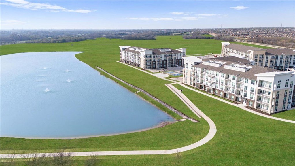 an aerial view of a building next to a lake