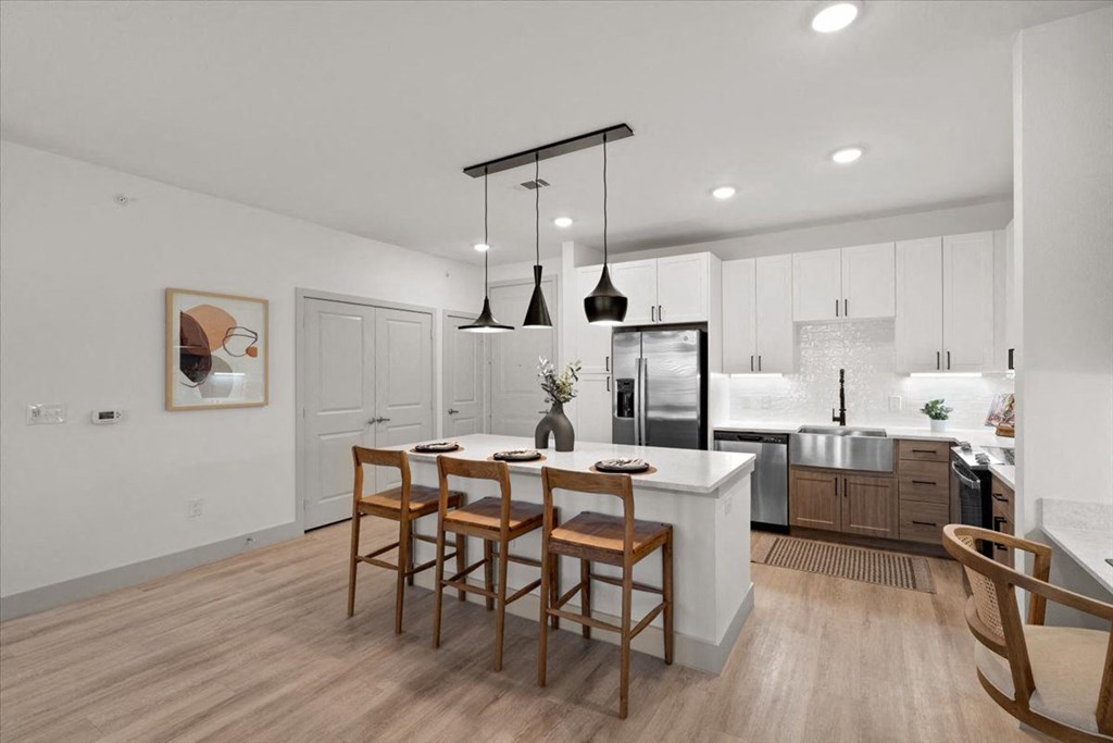 a kitchen with a center island with four chairs